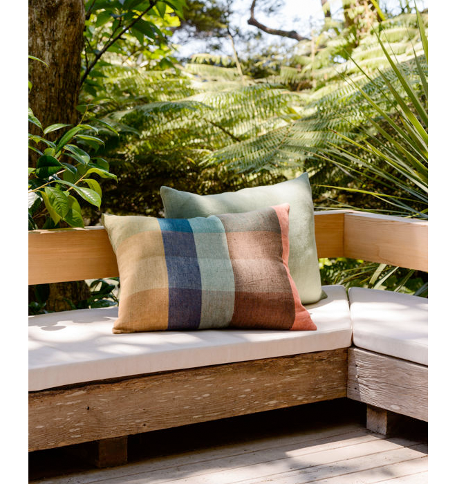 Colorful striped cushions on a wooden bench with a natural background