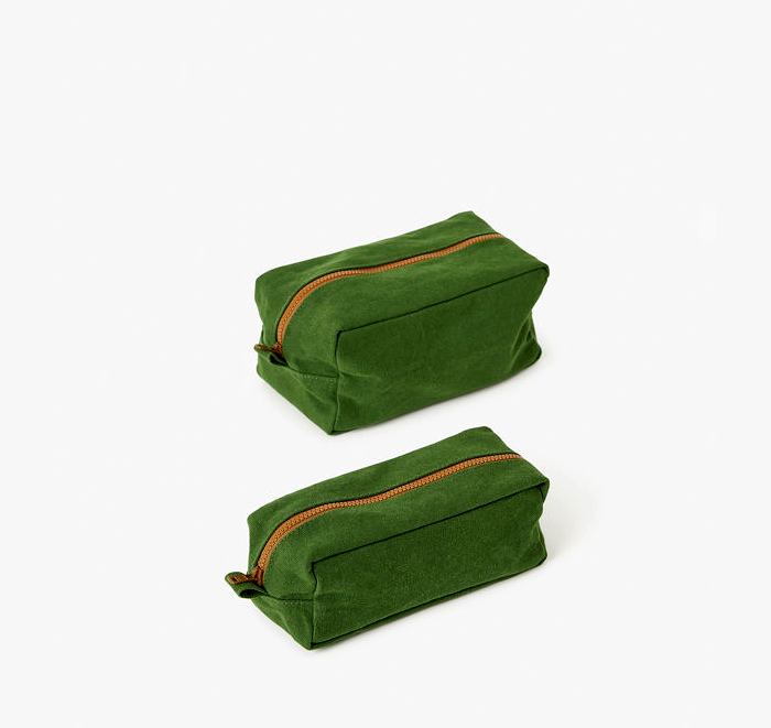 Two green fabric pouches with orange zippers on a white background