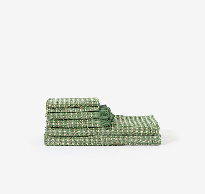 Set of green patterned towels on a white background