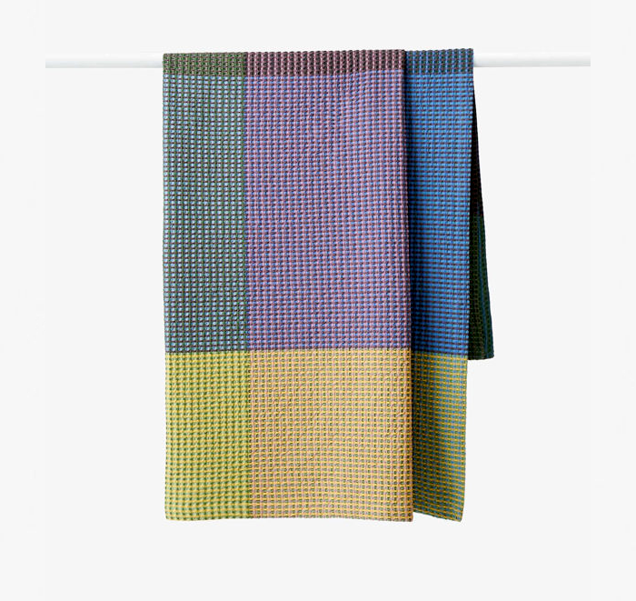 Colorful woven blanket with geometric pattern on a white background