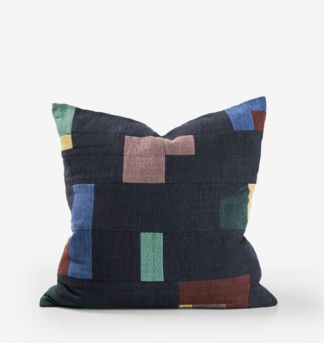 Multicolored geometric-patterned pillow on a white background