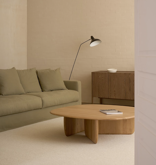 Modern living room with a beige sofa, wooden coffee table, and sideboard.