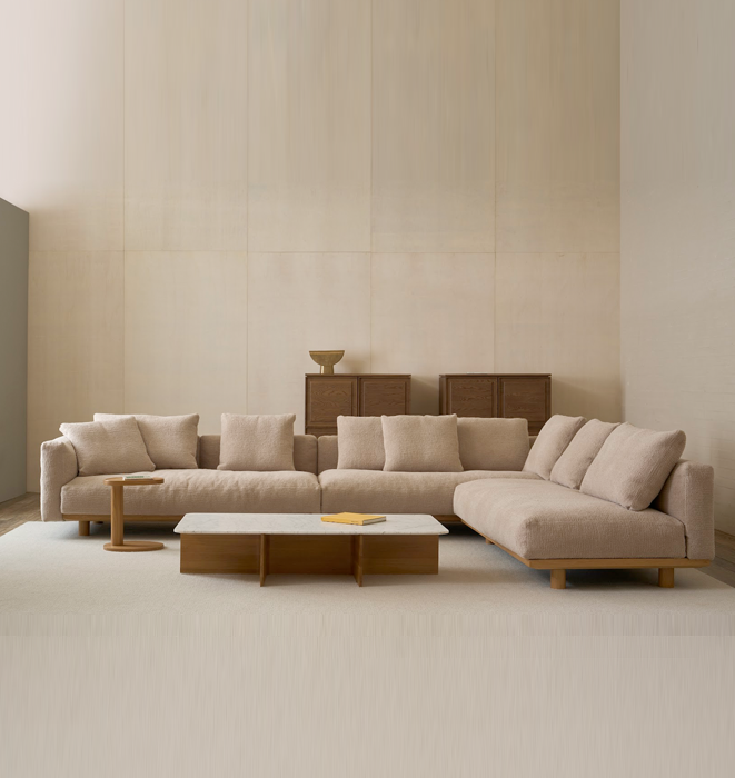 Beige sectional sofa in a minimalistic living room with a neutral color palette.