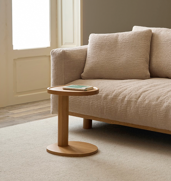 Beige sofa with a wooden side table in a living room setting