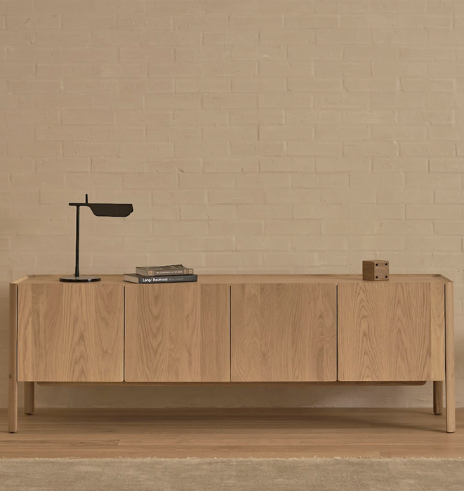 Wooden sideboard against a beige brick wall
