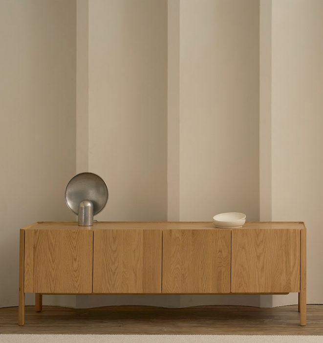 Wooden sideboard with decorative items against a striped wall.