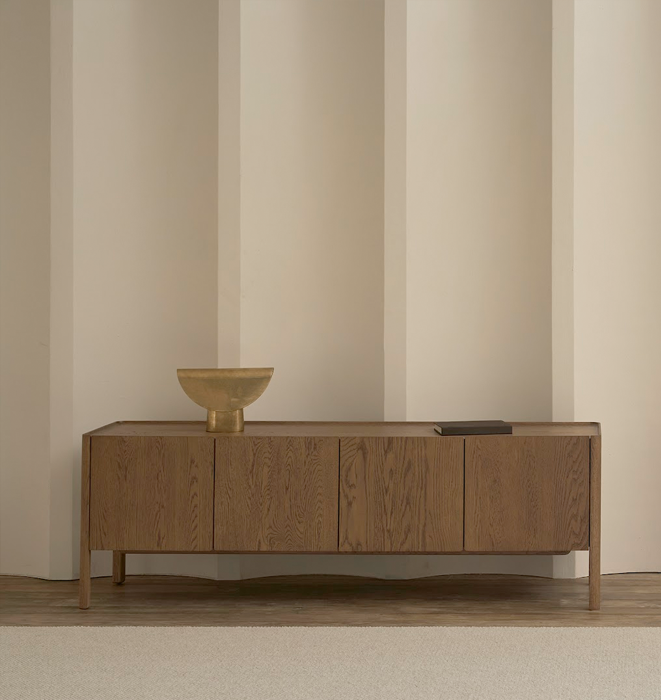 Wooden sideboard with decorative bowl against a striped wall.