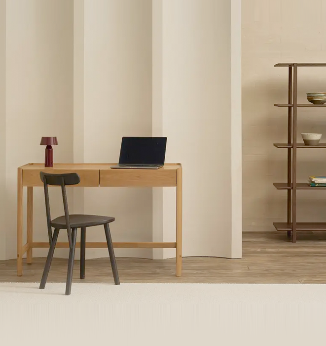 Minimalist home office with wooden desk, chair, and laptop.