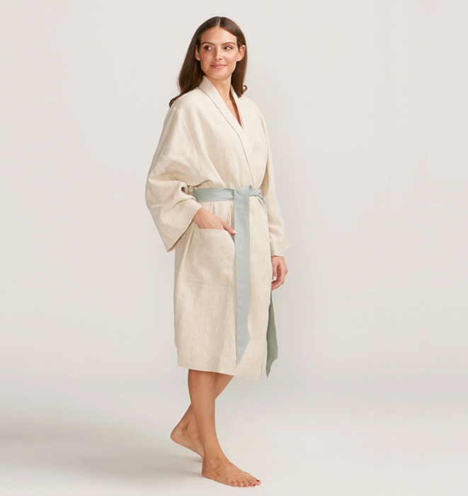 Woman wearing a beige bathrobe on a plain background
