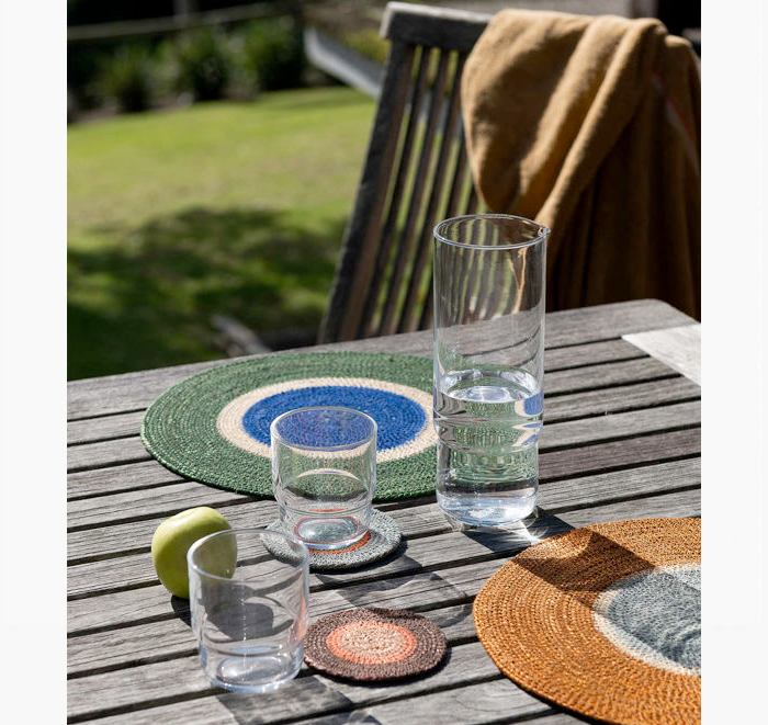 Outdoor setting with glasses and coasters on a wooden table