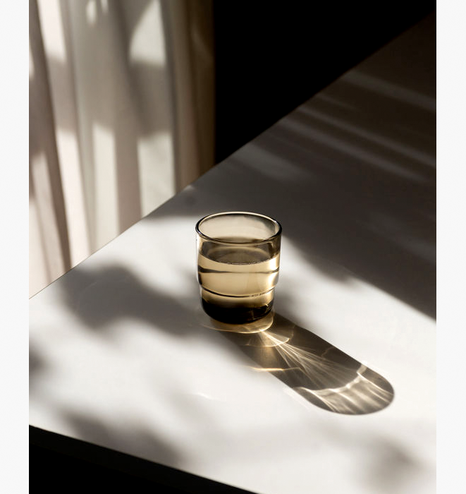 Glass tumbler on a white surface with soft shadows