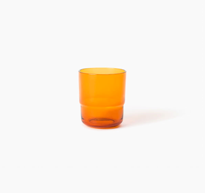 Orange glass tumbler on a white background