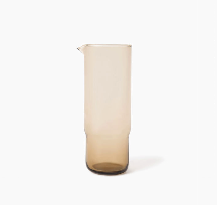 Glass pitcher with a gradient color from beige to brown on a white background